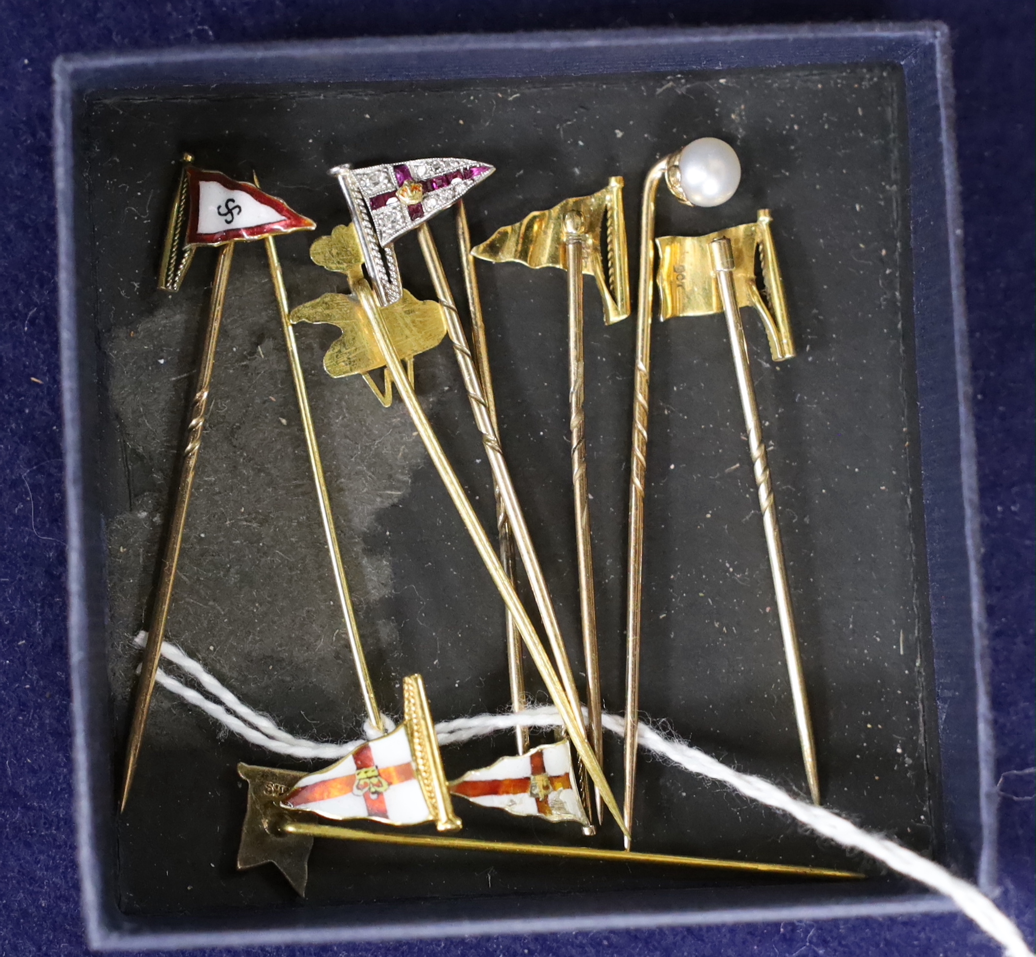 Five assorted 9ct and enamelled pennant stick pins, a yellow metal, a ruby and diamond set pennant stick and two others including enamel (stamped silver), approx. 54mm.